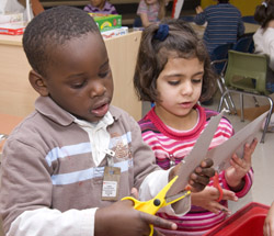 Preschoolers cutting with scissors